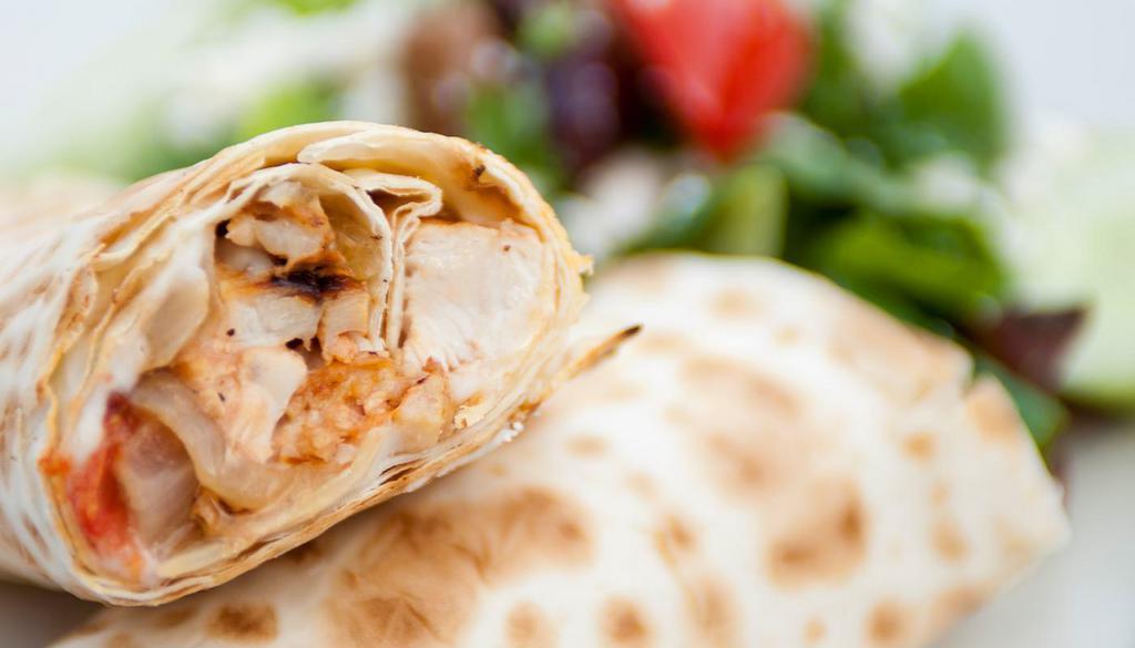 Lavash Shawarma Wrap · grilled marinated all-natural chicken breast, garlic sauce, roasted tomatoes and onions, lavash wrap, wood-fired and side greek salad