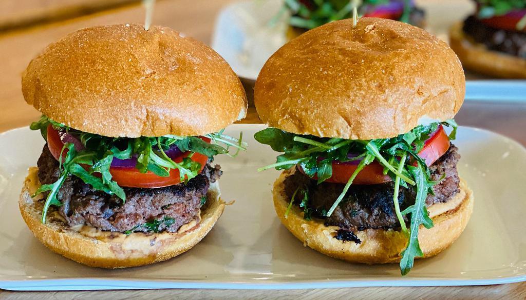 Kafta Beef* Burger · hand-formed beef, pomegranate molasses patty, mixed with minced parsley, jalapenos, onions, baby arugula, hothouse tomato, sliced red onion, sumac, chipotle hummus and bun (one burger)