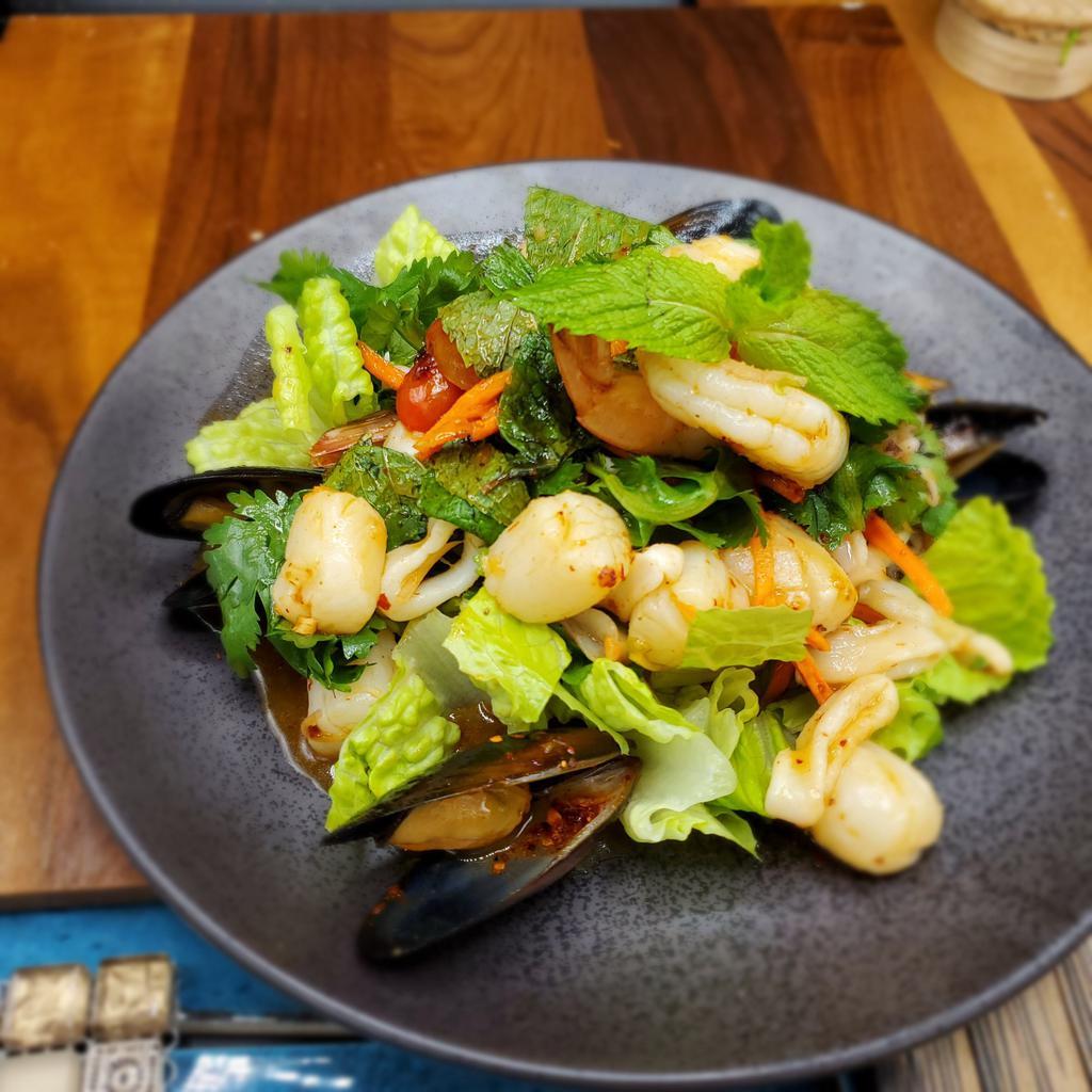 Seafood Salad (Yum Talay) · Combination of shrimps, scallops, mussels, squid with lemongrass, sweet chili paste, onion, tomato, lime juice, cilantro, and mint on bed of romaine