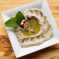 Baba Ghanouje · Roasted eggplant mixed with tahini sauce, lemon juice, and garlic, served with pita bread.