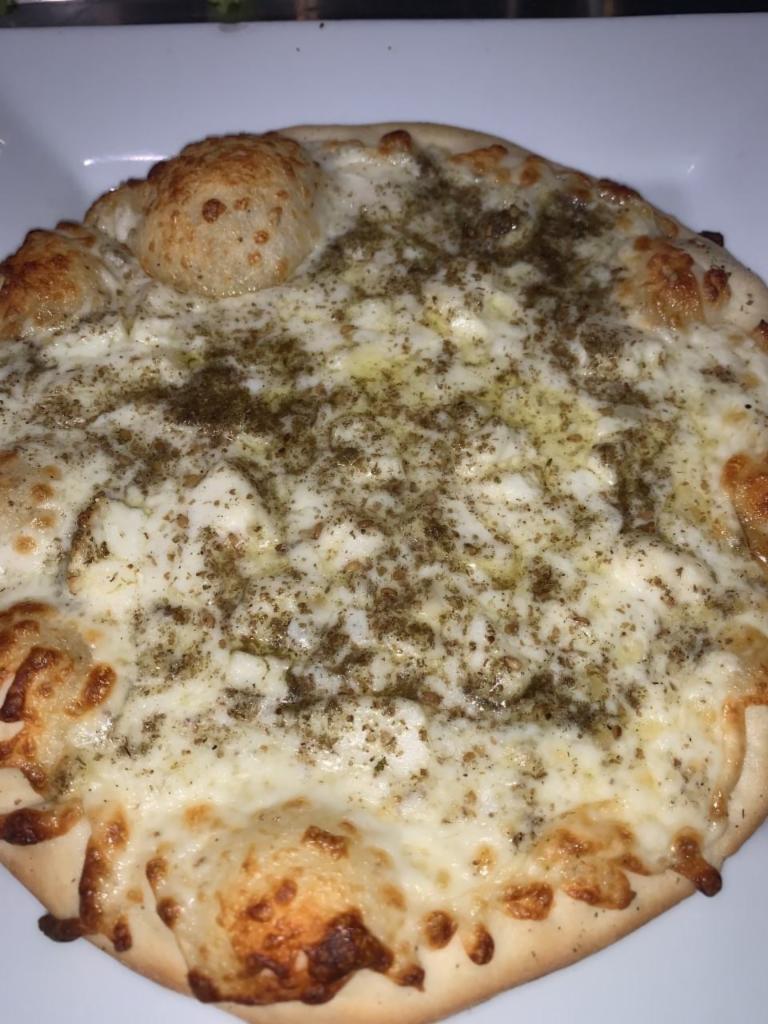 Halloumi and Mozzarrella Pizza · Halloumi cheese with zaatar and mozzarella drizzled with olive oil on a pizza dough