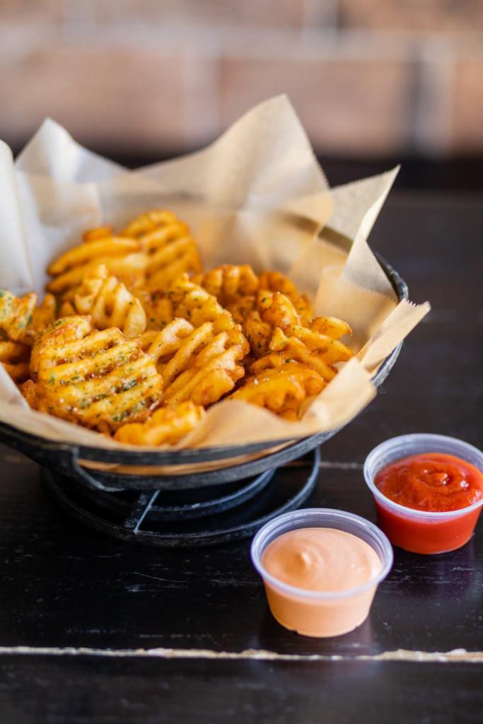 Waffle Fries · Waffle fries tossed with house seasoning, and parmesan cheese topped with parsley flakes. 