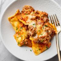 Baked Cheese Ravioli with Garlic Bread · 7 - Cheese Ravioli's topped with a delectable red sauce, encrusted mozzarella and parmesan c...