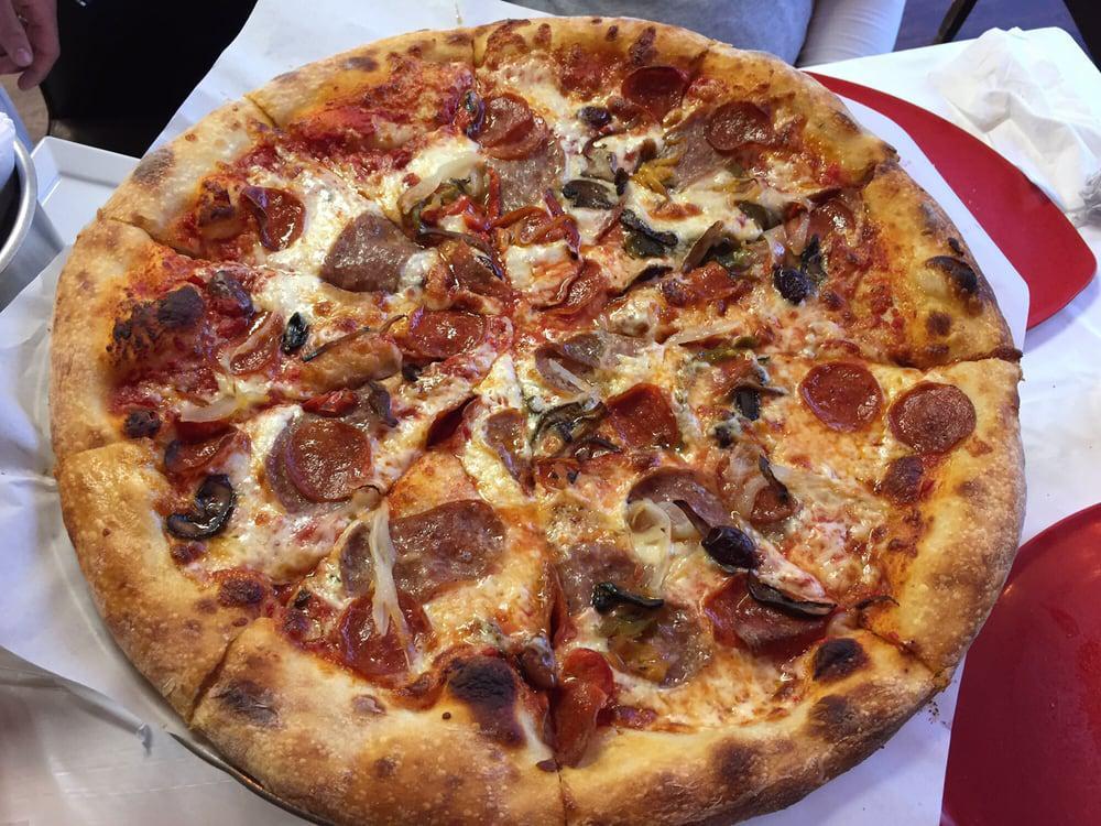 Classic Combo Pizza · Caramelized onions, roasted bell peppers, roasted mushrooms, black Mediterranean olives, house made sausage, pepperoni and tomato sauce.