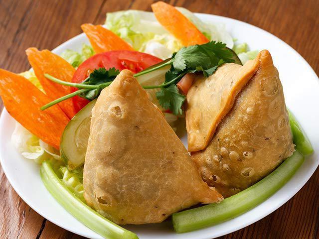 Vegetable Samosa · Traditional Indian deep fried pastries stuffed with potatoes, peas and light spices.