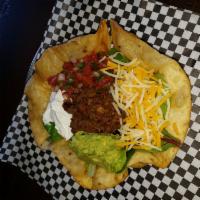 Taco Salad · Tortilla shell filled with fresh greens, scratch made taco seasoned ground beef, tomatoes, s...
