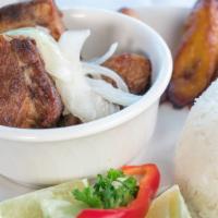 Masas de Cerdo · Pork chunks. Fried pork chunks topped with grilled onions. Served with white rice, black bea...
