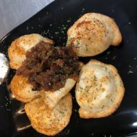   Perogies with Bacon Jam and Sour Cream · Soft stuffed dumplings with potato and cheddar