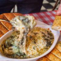 Spinach Artichoke Dip · A creamy spinach artichoke dip that comes with a side of garlic sticks for dipping.