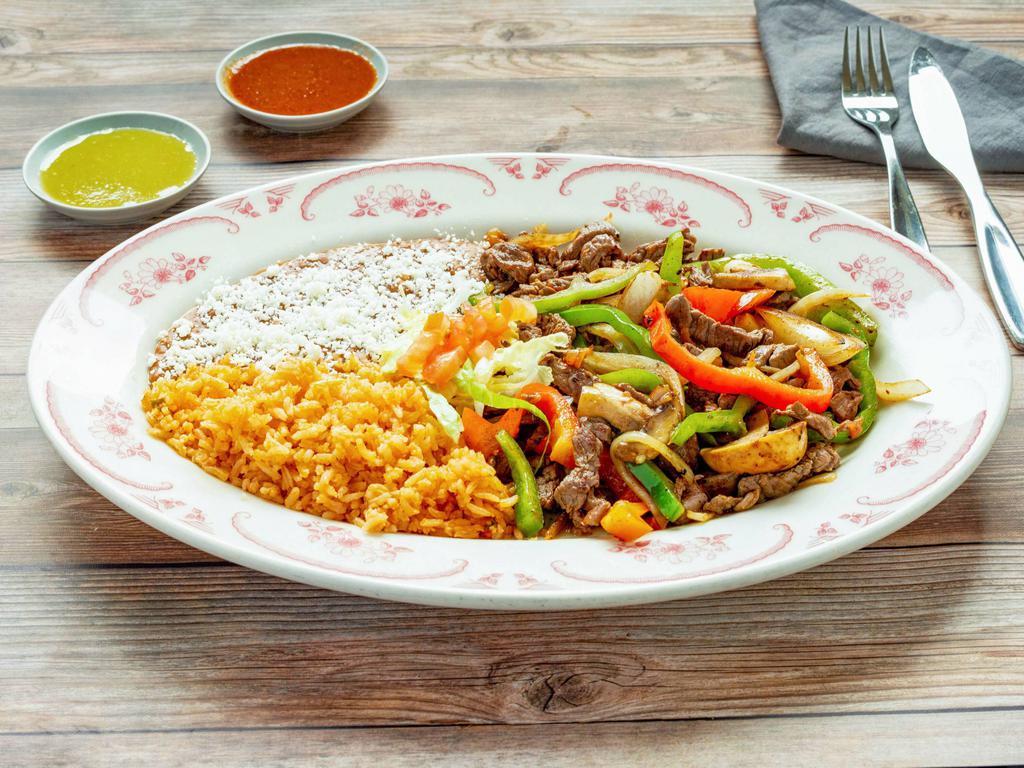 Carnitas de Res · Steak strips cooked and mixed with onions, green bell peppers and tomato. Served with rice and beans.