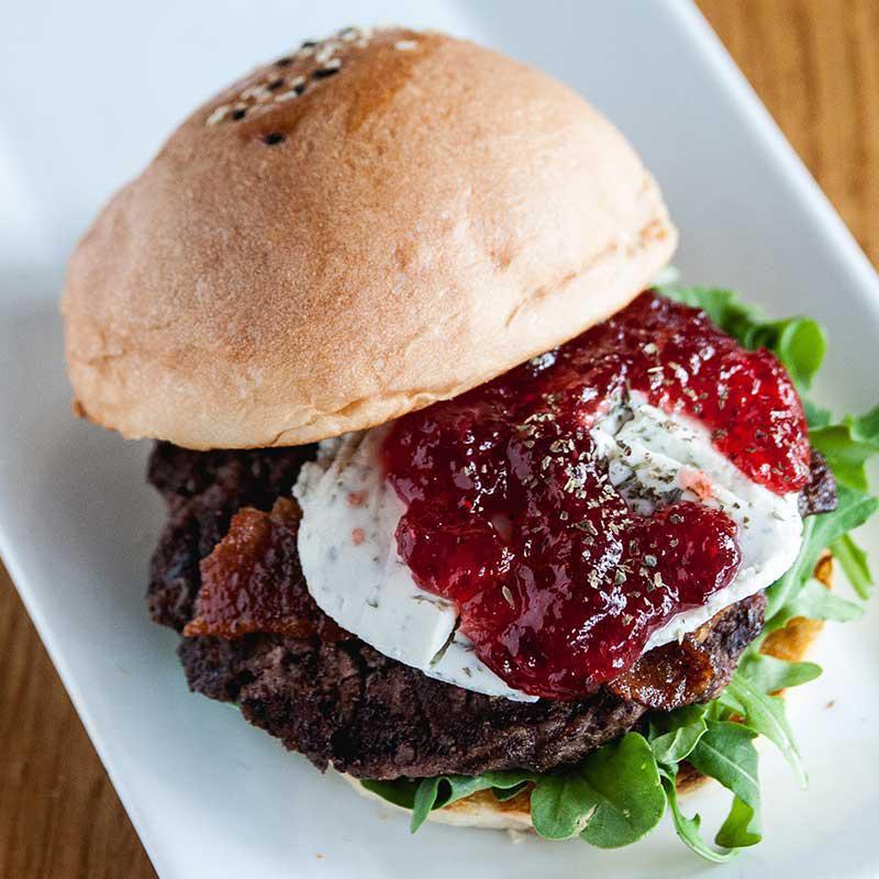 F.R.O.G. Burger · Homemade fresh basil goat cheese with F.R.O.G. (fig, raspberry, orange, and ginger) jam reduction, arugula, and candied bacon. 