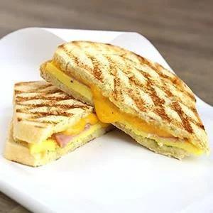 Breakfast Sandwich · Choice of meat, with Egg, cheddar,  with tomato, green pepper, and red onion, garlic butter spead on honey whole wheat, with choice of bacon, ham or sausage