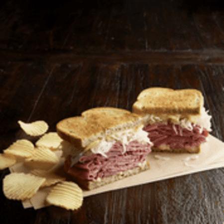 Reuben the Great Sandwich · Hot corned beef or pastrami, Swiss, sauerkraut, Thousand Island dressing, grilled rye. Served with chips or baked chips.