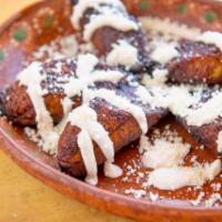 Maduros Con Crema · Fried sweet plantains, topped with crema and queso cotija.