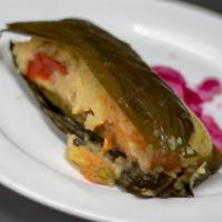 Tamales Centro Americano · Central American style Tamal stuffed with pork or chicken, wrapped in a green banana leaf.