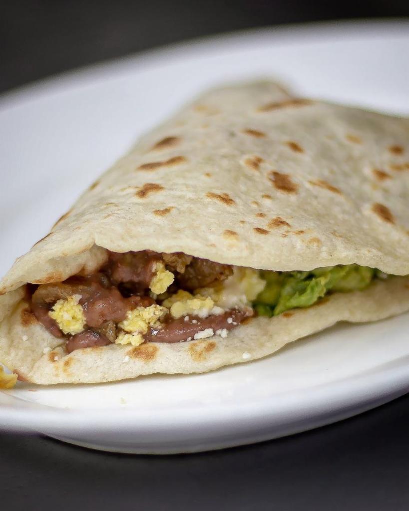 Baleada con Huevo · A traditional Honduran Delight - Baleada composed of a thick handmade flour tortilla stuffed with mashed refried beans, crema, crumbled cheese, eggs and avocado.
Con Huevo ,Aguacate, Frijoles, Queso y Crema