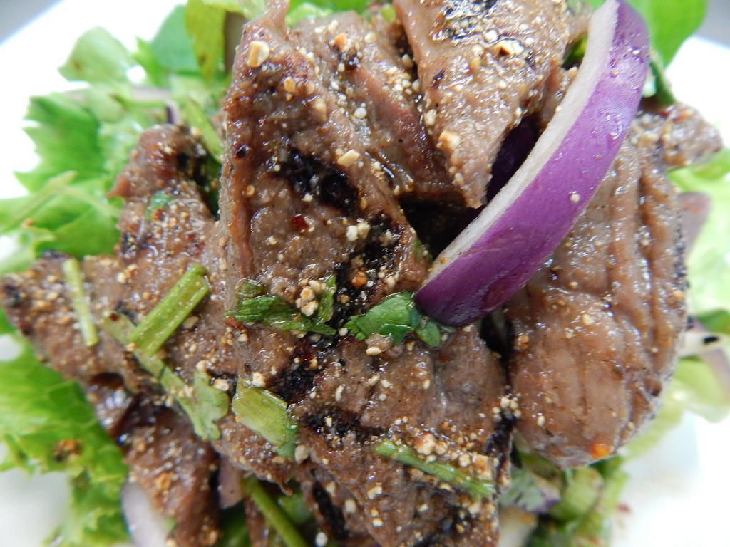 8. Beef Nahm Tok · Grilled beef seasoned with scallions, roasted rice powder, cilantro, mint, red onions, chili powder, and fresh lime juice. Medium spice.