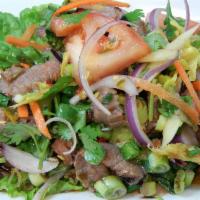 18. Yum Nua Salad · Beef salad. Grilled flank steak, thinly sliced, tossed with spicy lime vinaigrette and mixed...