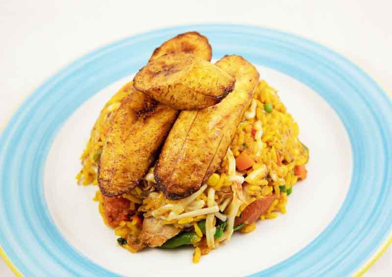 Arroz con Pollo · Served with fried plantains, rice and beans.
