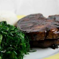 Brazilian-Style Pork Chops · Pork chops with garlic-wine sauce and sauteed collard greens. Served with Rice & Beans