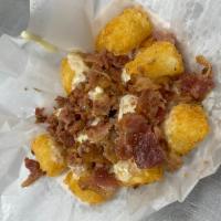 Loaded Tots · tater tots topped w/ cheese sauce & bacon served with a side of sour cream