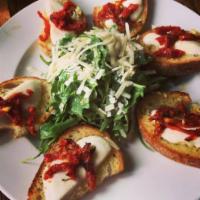 Bruschetta Mozzarella · Toasted Garlic Cibatta Crisps  Topped With Melted Fresh Mozzarella Cheese And Sun-Dried Toma...