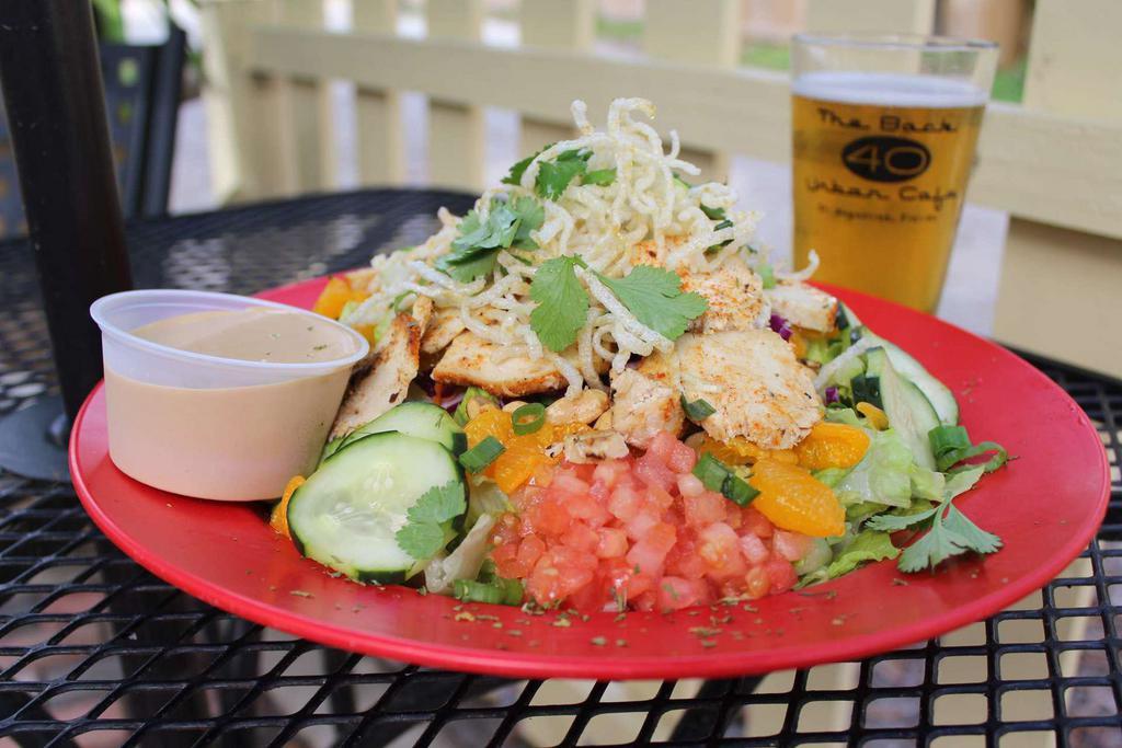 Thai Chicken & Peanut Salad · Grilled chicken over chopped romaine, shredded red cabbage and carrots, diced tomatoes, marinated cucumbers, mandarin oranges, roasted peanuts and topped with crispy rice noodles, green onions and cilantro and served with our spicy Thai peanut dressing.