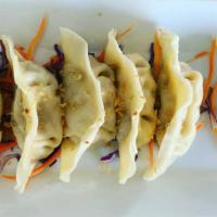 Steamed Dumplings  · Steamed dumplings wrapped with chicken,cabbage,and onion topped with fried garlic served wit...