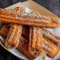 Churros VB · A thick fritter of fried dough topped with cinnamon and sugar and served with a chocolate or...