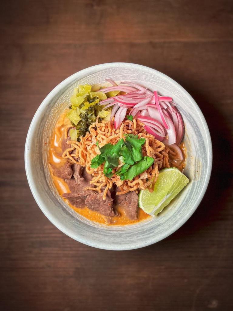 Kao Soi  · Northern Thai-style beef turmeric curry noodles. egg noodles, shallot, pickled mustard green, scallion, Thai chili paste and coconut milk. Medium spicy.  ( can not change noodle )