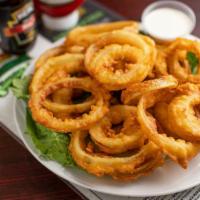 11. Onion Rings · Served by the foot, stacked high with dipping sauce.