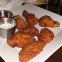 Jawaneh · Baked then fried chicken wings marinated and served with garlic creme sauce. Seven pieces.