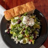 Greek Salad · Spring mix and romaine, tomatoes, olives, onion, feta, squeezed lemon, and olive oil.