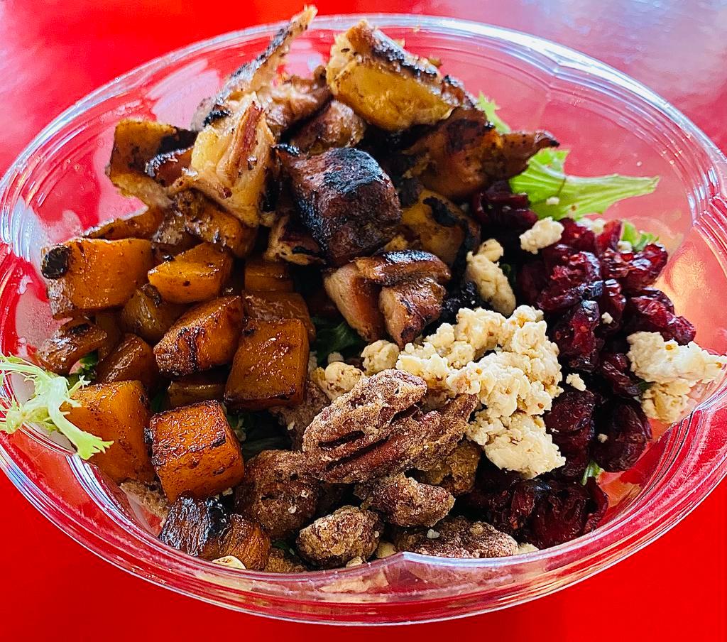 Chicken Power Bowl · Seasoned smoked diced chicken thigh, sautéed butternut squash, honey fig goat cheese, candied pecans, dried cranberries and quinoa over mixed greens topped with a maple balsamic vinaigrette.