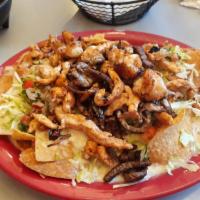 Nachos Carbon · Steak, grilled chicken, and grilled shrimp covered with white queso sauce, fresh lettuce, an...