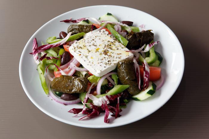 Greek Salad · Romaine lettuce, tomatoes, cucumbers, feta, black olives, anchovies, dolmadakia and garnish. served with balsamic vinaigrette