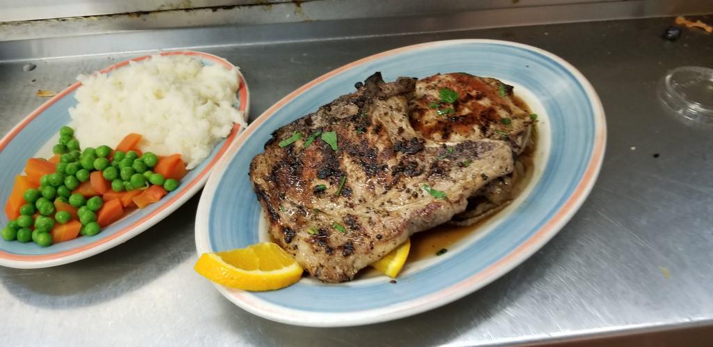 Pork Chops · Butcher cut pork chops broiled, with caramelized apples and onions. Served with potato, veggie, and soup/or salad .