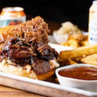 Smoked Tri Tip Sandwich · House made BBQ sauce, crispy onions, brioche bun, coleslaw, side of fries, and a pickle.