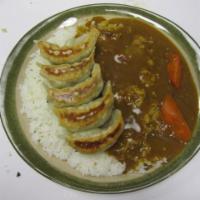 Gyoza Curry Rice  · Pan fried gyoza with golden curry sauce with carrot on white rice. 