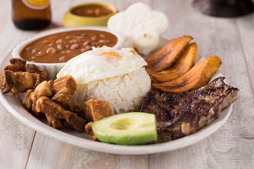 Bandeja Paisa Especial · Beef steak, egg pork rinds, arepa, white rice and beans, and sweet plantains.