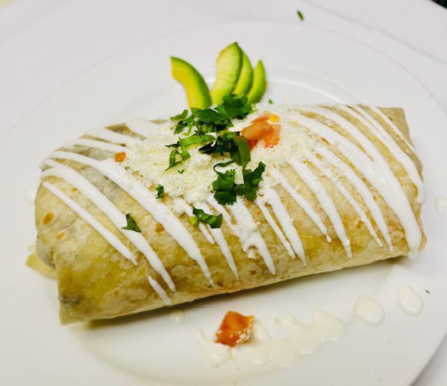 Pollo Asado Burrito · Grilled chicken. Flour tortilla rolled with rice, refried beans, onions, cilantro and queso fresco. Topped with sour cream and cheese.