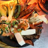 Molcajete Jalapeno · Mixed grilled chicken, steak and shrimp with cactus, spring onions and fresh cheese over spi...