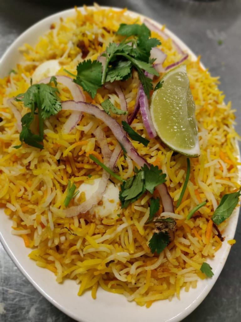Egg Biryani · Basmati rice cooked with eggs, blended with herbs and spices then garnished with egg and served with yogurt raitha and chili peppers gravy.