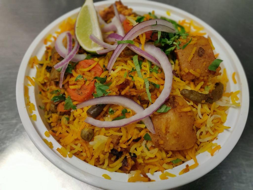 Vegetable Dum Biryani · Basmati rice cooked with a variety of fresh seasonal vegetables, blended with herbs and spices and served with yogurt raitha and chili peppers gravy.