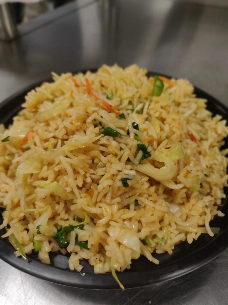 Vegetable Fried Rice · Steamed rice stir fried on a wok along with freshly chopped carrots, beans and spring onions.