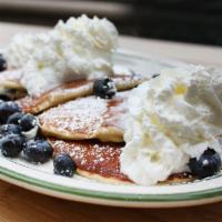 Veruca's Blueberry Pancakes · Stack of Mama's hotcakes with blueberries cooked in. Topped with blueberries and whipped cre...