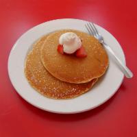 Buttermilk Pancakes · Buttermilk pancakes topped with freshly whipped cream and seasonal berries.