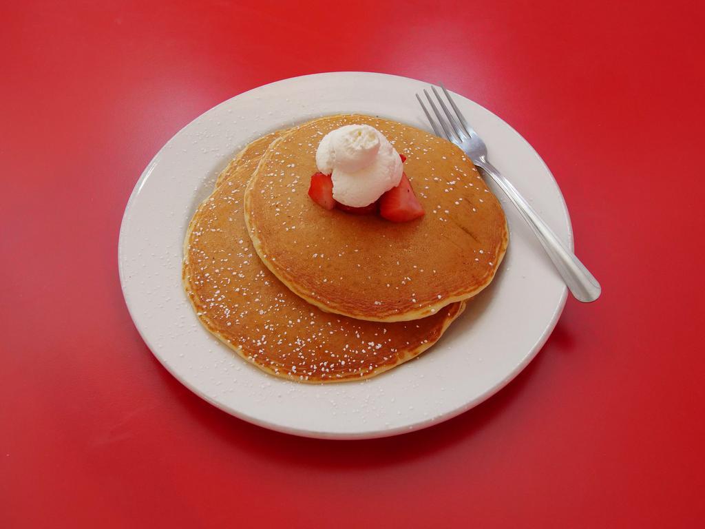 Buttermilk Pancakes · Buttermilk pancakes topped with freshly whipped cream and seasonal berries.