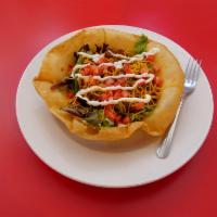 Taco Salad · A bed of greens topped with seasoned ground beef, re-fried beans, cheddar cheese, sour cream...