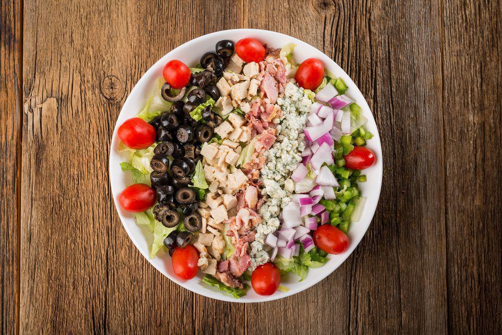 Chopped Salad · Finely chopped romaine and iceberg lettuce, spinach leaves, grilled chicken, green
pepper, red onion, black olives, bacon, grape tomatoes and bleu cheese crumbles.